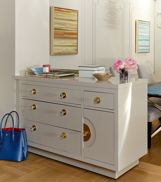 Neutral hued Custom Entry Cabinet with brass accents does double duty as storage for dining room. 